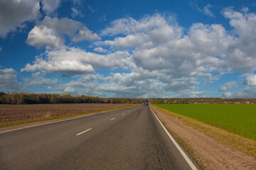 Autumn landscape and sunny evening, orange road and highway, asphalt and roadside.
