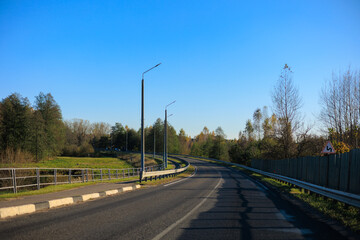 Autumn landscape and sunny evening, orange road and highway, asphalt and roadside.