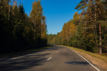 Obraz premium Autumn landscape and sunny evening, orange road and highway, asphalt and roadside.