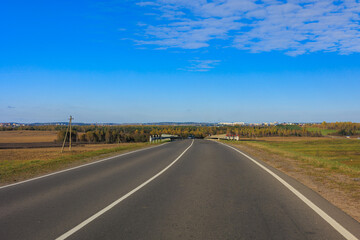 Autumn landscape and sunny evening, orange road and highway, asphalt and roadside.