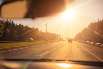 Autumn landscape and sunny evening, orange road and highway, asphalt and roadside.