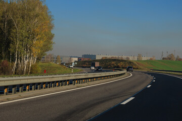 Autumn landscape and sunny evening, orange road and highway, asphalt and roadside.
