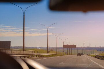 Autumn landscape and sunny evening, orange road and highway, asphalt and roadside.