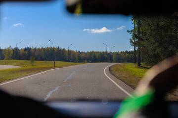 Autumn landscape and sunny evening, orange road and highway, asphalt and roadside.