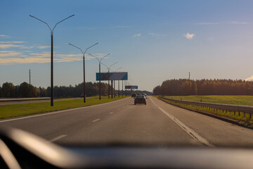 Autumn landscape and sunny evening, orange road and highway, asphalt and roadside.