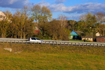 Autumn landscape and sunny evening, orange road and highway, asphalt and roadside.