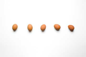 Five evenly spaced brown eggs centered on a pure white background; symmetrical, airy composition ideal for banners or menu headers.