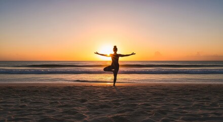 Silhouette of a woman in yoga pose at sunrise on a beach