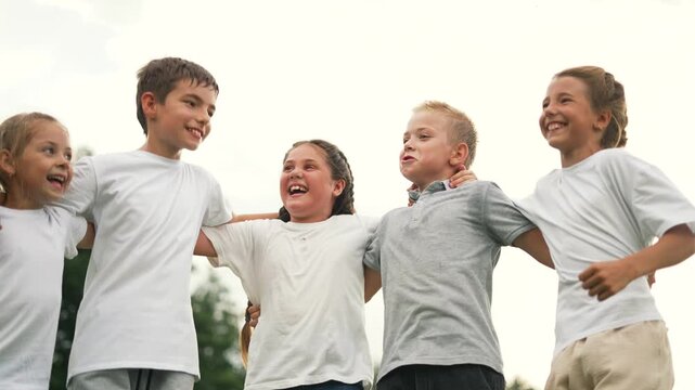 Child laugh hug friendship play in park outdoor summer day with kid smile and joy as group share laughter running together showing happiness unity and carefree energy full of smile play and laughter