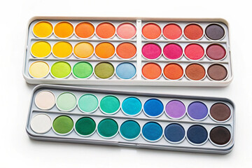 Two metal palettes filled with vibrant watercolor paint pans