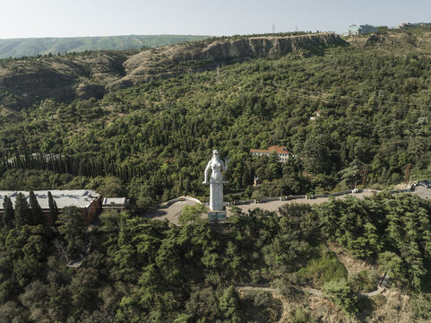 Aerial view of Kartlis Deda statue standing tall amidst lush greenery, a serene sentinel overlooking the city's embrace of nature, Tbilisi, Tbilisi, Georgia.