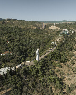 Aerial view of Kartlis Deda statue stands majestically amid lush greenery, overlooking the city below, Tbilisi, Tbilisi, Georgia.