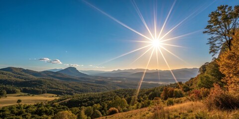 Sunburst over Mountain Vista Forested Peaks Under Clear Blue Sky