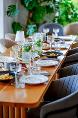 An elegant dining table with delicious dishes, crispy salads, glowing candles and colorful floral arrangements