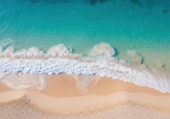 Fototapeta premium Aerial view of a tropical beach with turquoise water and gentle waves rolling onto the sandy shore, perfect for vacation and summer travel