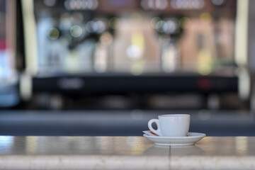 A Delicious Hot Espresso Coffee Cup Sitting on a Coffee Bar Counter with a Blurred Espresso Machine in the Background Perfect for Cafe and Morning Beverage Concepts
