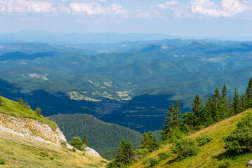 Green slopes and forested ridges around Jahorina, with dramatic landscape fading into mountain blue...