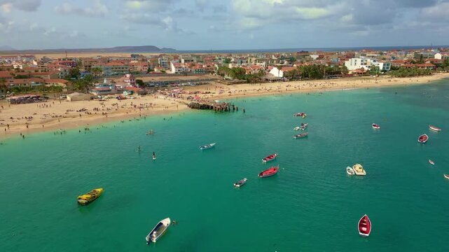 Cinematic drone footage of Santa Maria beach and pier, Sal Island, Cape Verde. Captured at golden hour with turquoise waters, fishing boats and tropical atmosphere in 4K and HD formats.