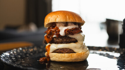 Massive gourmet burger with two juicy beef patties, overflowing melted cheese, crispy bacon, rich...