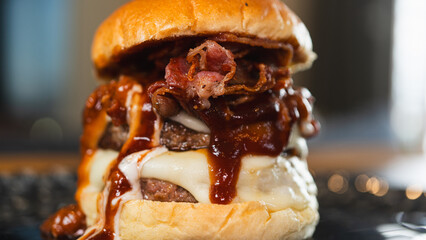 Massive gourmet burger with two juicy beef patties, overflowing melted cheese, crispy bacon, rich...