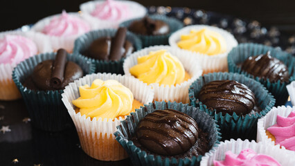 Beautiful chocolate and assorted cupcakes on an elegant plate, perfect for parties or family gatherings. Soft lighting and shallow depth of field.