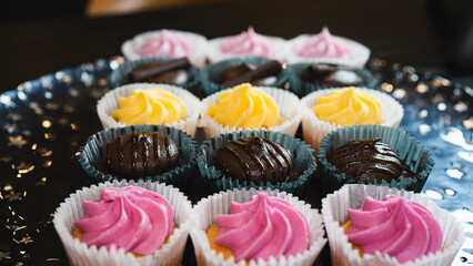 Beautiful chocolate and assorted cupcakes on an elegant plate, perfect for parties or family gatherings. Soft lighting and shallow depth of field.