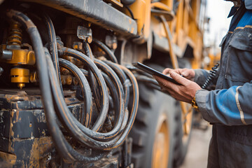 Mechanic with tablet computer control and fix problem of hydraulic hoses from industrial mining truck