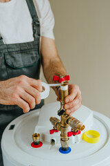 Worker wrapping plumbing tape around a fitting on a water heater