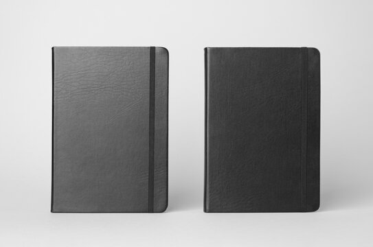 Mockup of two black notebooks on a gray background