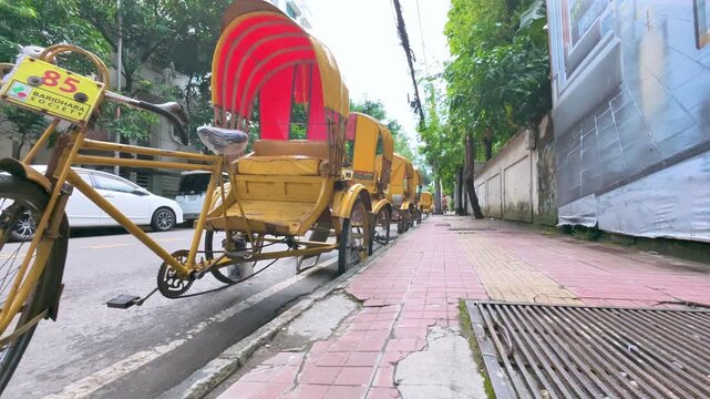 Row of Yellow Rickshaws Parked on a City Sidewalk