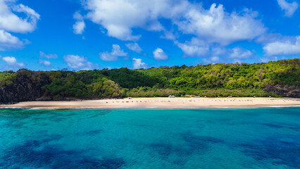 Praia do Americano em Fernando de Noronha, com areia clara, mar azul e vegetação costeira,...