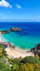 Fototapeta premium Praia do Cachorro em Fernando de Noronha, com águas turquesa e formações rochosas, famosa por sua beleza natural, piscinas e vista deslumbrante do mar tropical