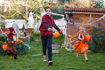 Fairy leads pirate and skeleton across Halloween-decorated yard