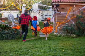 Children race through Halloween yard amid festive decorations