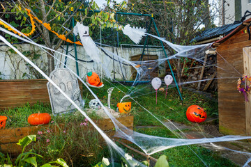 Empty Halloween yard scene with cobwebs, pumpkins, and ghosts