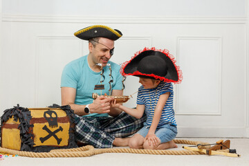 Dad with child enjoy pirate-themed fun in ship and pirate chest