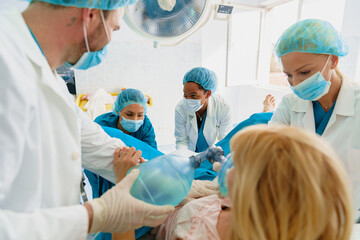 Blonde Caucasian Woman in Labor with Medical Team Assisting in a Hospital Delivery Room