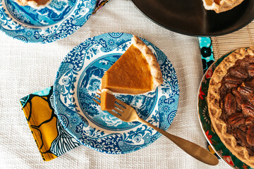 Homemade pecan and pumpkin pie desserts served at holiday dinner table