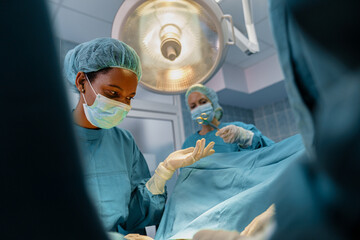 Diverse Medical Team Of Surgeons Working Together During Complex Operation In Hospital Operating Theater