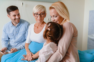 Fototapeta premium Sweet Caucasian Family Visiting Grandmother at Hospital Sharing Smiles and Love