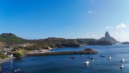 A Baía do Porto em Fernando de Noronha destaca-se por suas águas calmas, embarcações coloridas...