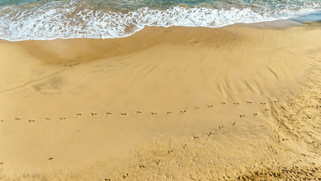 Fotografia de pegadas na areia dourada de uma praia em Fernando de Noronha, simbolizando tranquilidade, viagem, f&eacute;rias e conex&atilde;o com a natureza