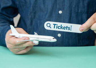 Man holds plane and search bar for tickets. Travel planning. Ticket booking. Online search....