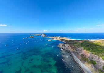 Foto aérea de Fernando de Noronha, mostrando praias, montanhas e vegetação nativa.