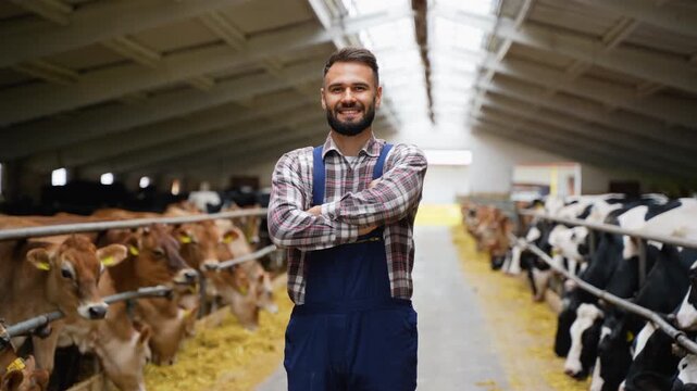 Farmer smiling with arms crossed in cowshed