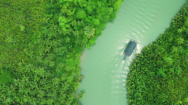 Aerial view of a boat navigating the green Yavari River, surrounded by tropical jungle, along the border of Brazil and Peru.