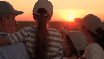 Happy farm family, field. Dad mom kids daughters hugging happily against sunset field, silhouette. Loving parents with their children in sun. Happy future dream concept. Parents dad mom girl children © Victoriia