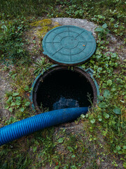Process of cleaning up sewage collector. Pumping out household septic tank