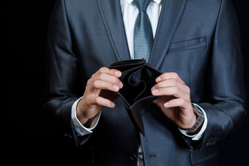 Empty wallet held by a businessman in a suit