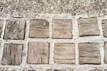 Old wooden road made of square timber blocks with concrete joints. Rustic texture close-up background for design or architecture. Budapest, Hungary.